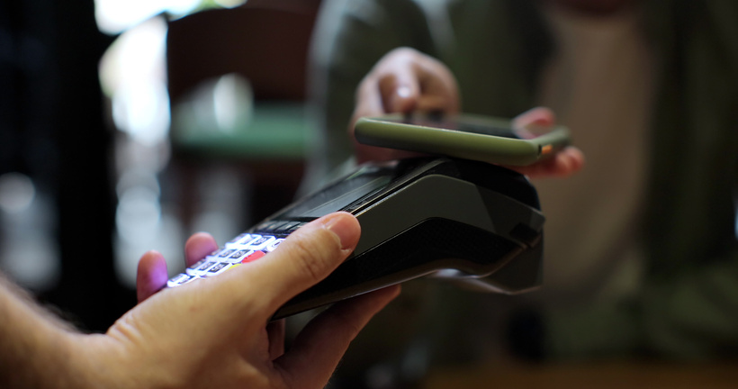 Man pay by smartphone on electronic payment machine or card